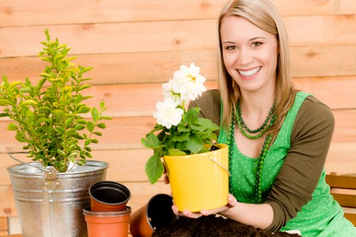 Operative wearing PPE and using a hedge trimmer safely
